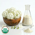 Wooden bowl with Hydrangea white flowers, glass beaker with powder, and USDA Organic label on a white background