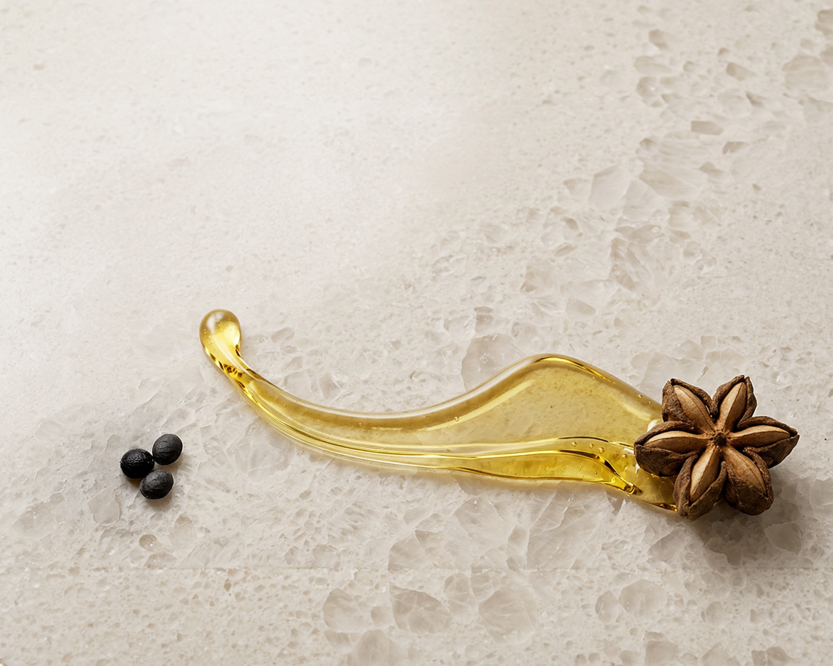 Sacha inchi star seed with an oil splash and three individual seeds on a quartz surface